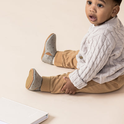 Toddler sitting wearing baby boots