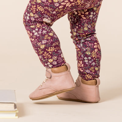 Toddler wearing Archie baby boots in blush pink with floral trousers