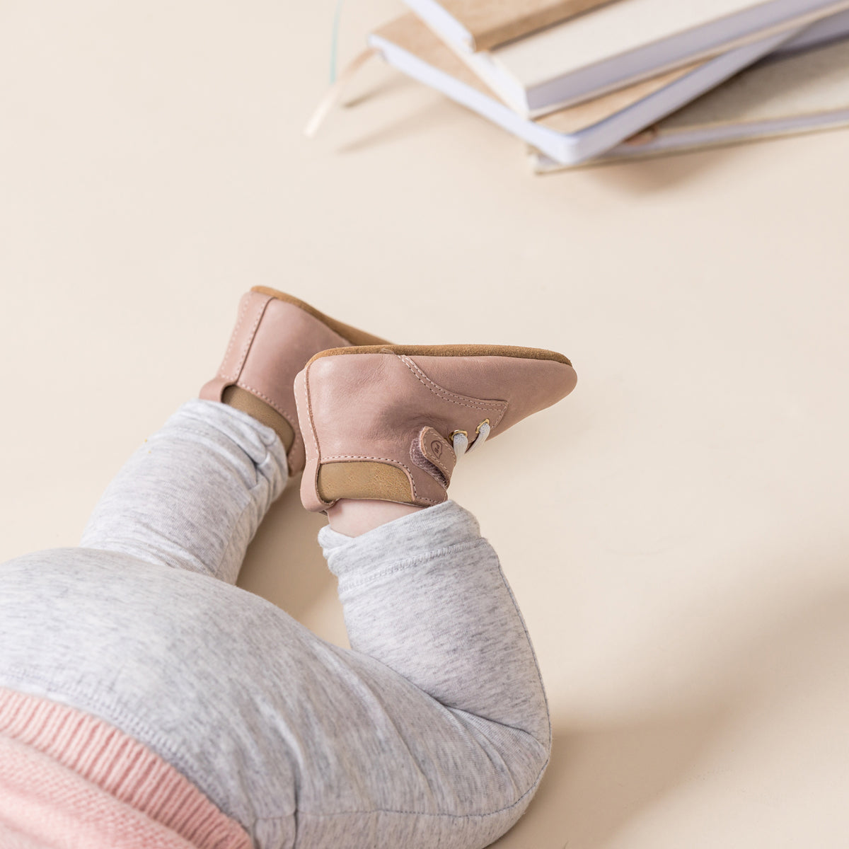 Baby wearing Archie baby boots in blush pink