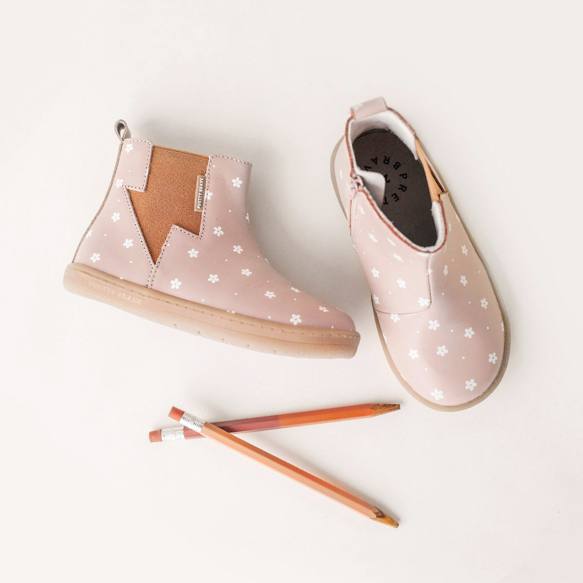 Pair of Electric boot design in colour Primrose next to two pencils