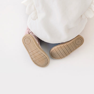 Child sitting on floor wearing Electric boot design in colour Primrose
