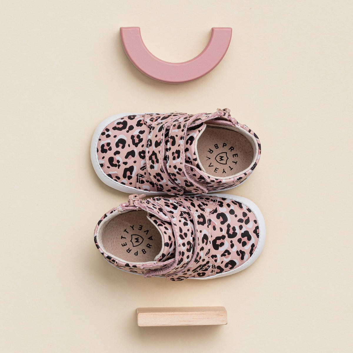 Top view of Hi Top shoe in leopard print next to wooden shoe