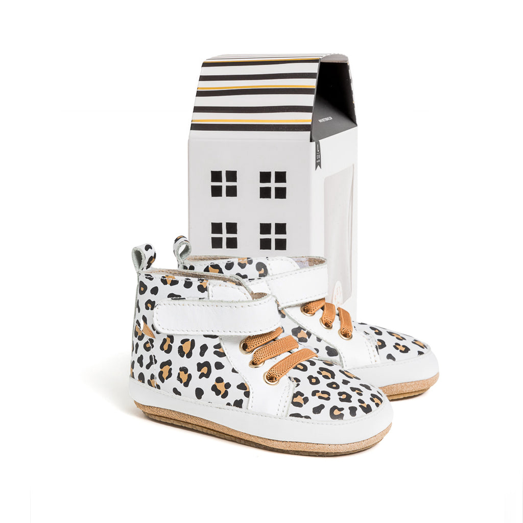 Hi Top shoes with leopard detail next to cardboard box 