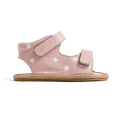 Side view of baby pink sandals with white daisy detail