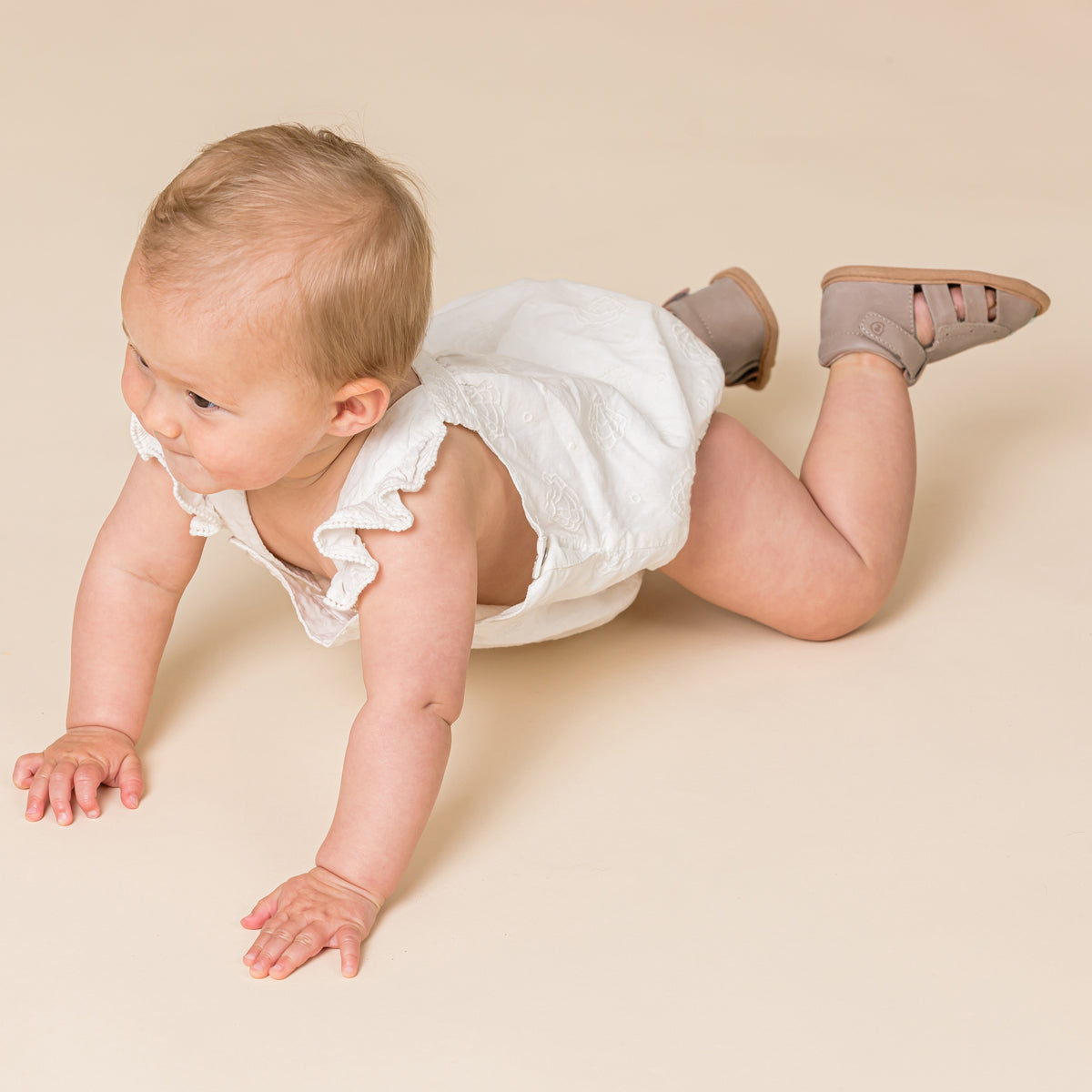 Baby crawling on ground wearing Charlie sandal in Taupe colour