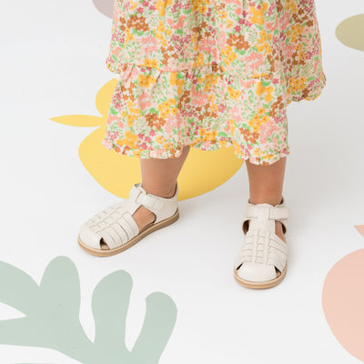 Child wearing Frankie sandal in colour Stone wearing flower dress